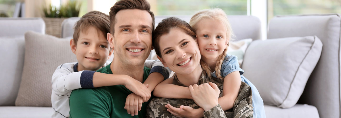 Family smiling in a living room.